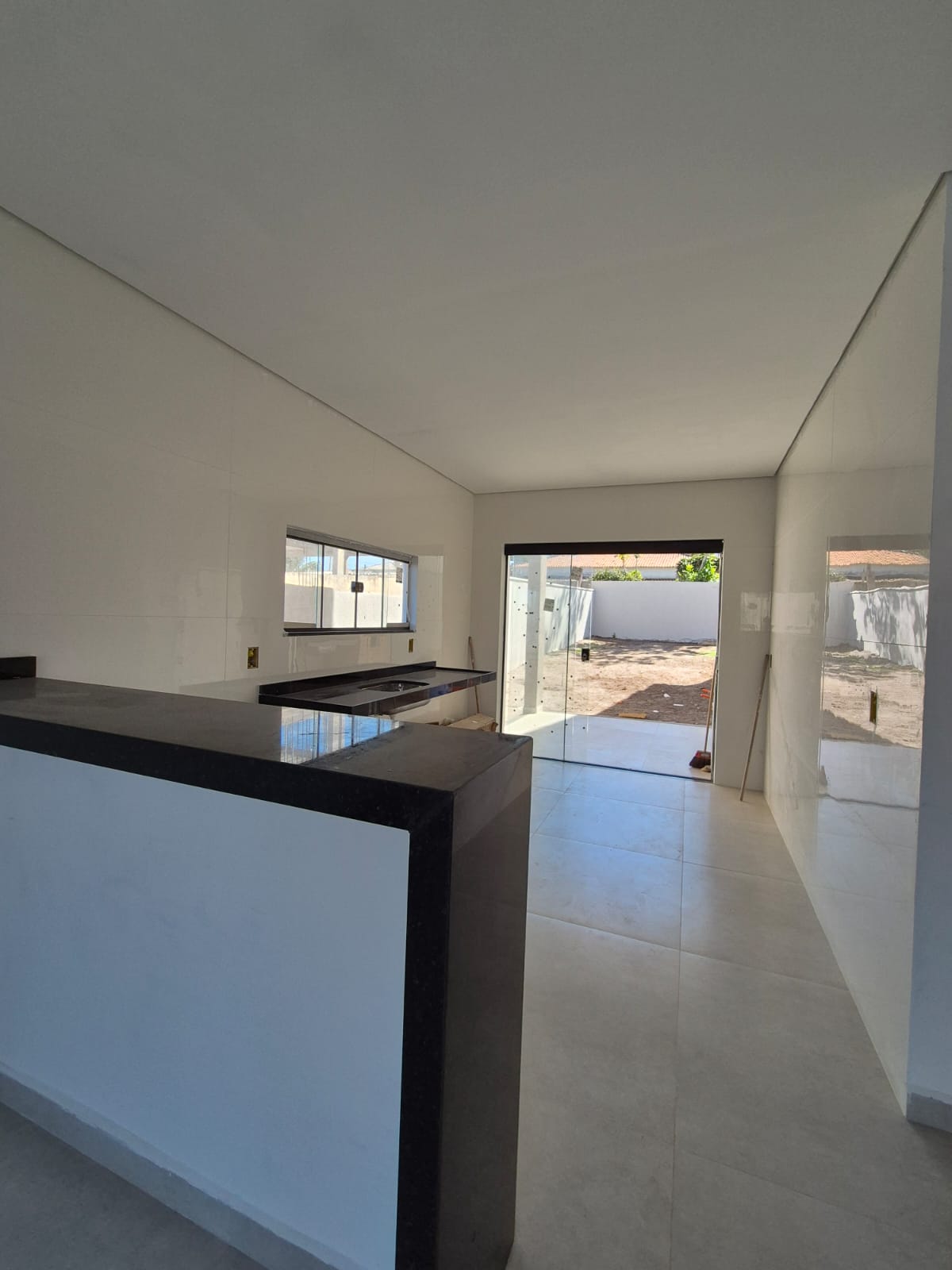 Cozinha com bancada em granito e vão para a área externa