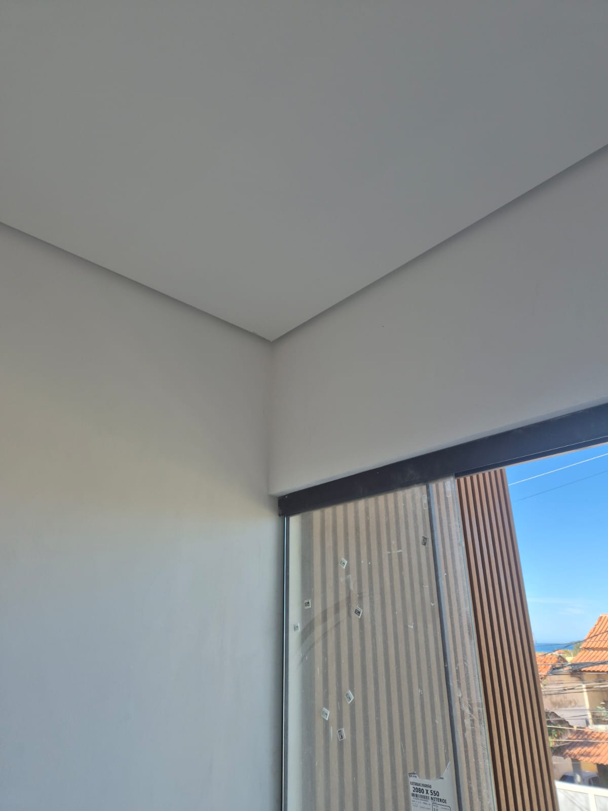 Rebaixamento de teto em drywall tabicado junto à porta de vidro com vista para o mar