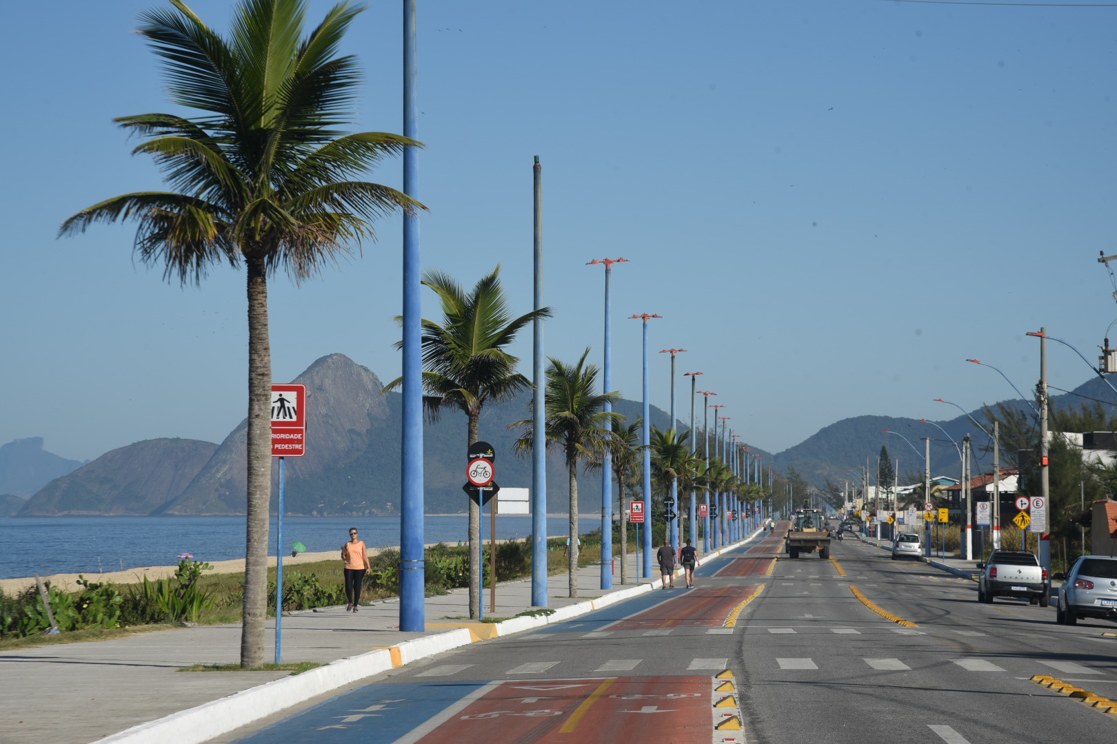 Avenida da orla de Itaipuaçu com coqueiros, ciclovia e mar ao fundo